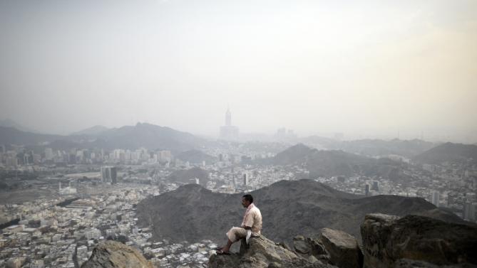 Description: A Muslim pilgrim looks at Mecca from the top of Noor mountain where the Hiraa cave is located on September 19, 2015 as more than a million Muslims from around the world converge on the holy city of Mecca for the annual hajj pilgrimage