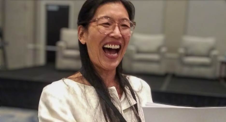 A person laughing with her mouth open  Description automatically generated