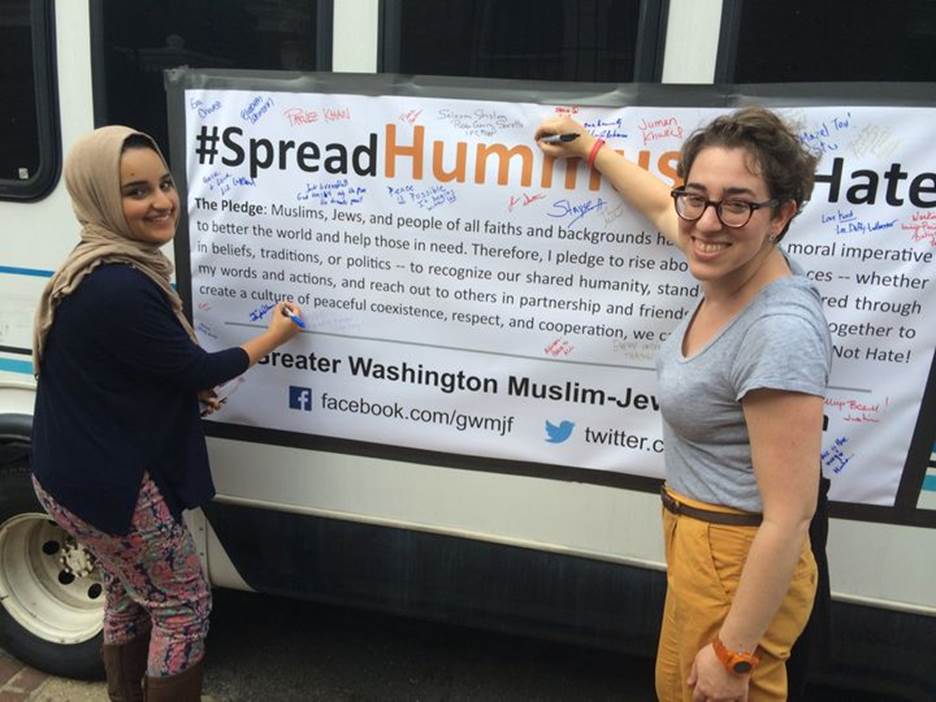 Spread Hummus Not Hate organizer Symi Rom-Rymer signs a pledge of peace with a Muslim student from the University of Maryland.