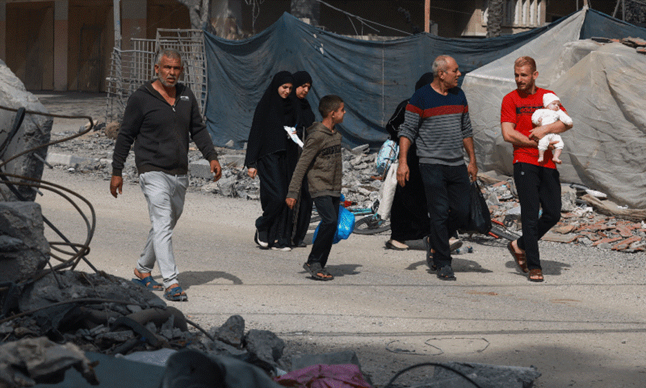 A Palestinian family walks past debris in Rafah, in the southern Gaza Strip on November 13, 2023. — AFP