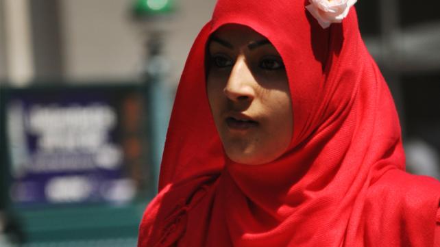 A person wearing a red head scarf  Description automatically generated