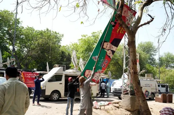 Municipal workers remove Imran Khan posters in Lahore, Pakistan, May 20, 2023.<span class=copyright>K.M. Chaudary/AP</span>
