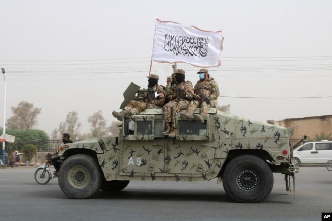FILE - Taliban fighters patrol on the road during a celebration marking the second anniversary of the withdrawal of U.S.-led troops from Afghanistan, in Kandahar, south of Kabul, Afghanistan, Aug. 15, 2023.