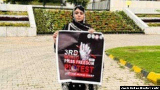 Javeria Siddique holds a banner on Press Freedom Day in Islamabad, Pakistan. Siddique says she now speaks up for everyone. Because they all have the option to be reunited with their loved ones. I don't have that option.”