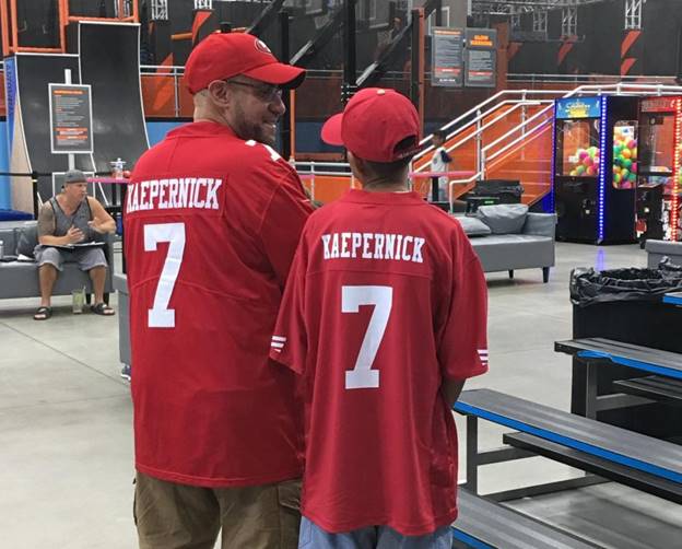 Two men wearing red jerseys  Description automatically generated