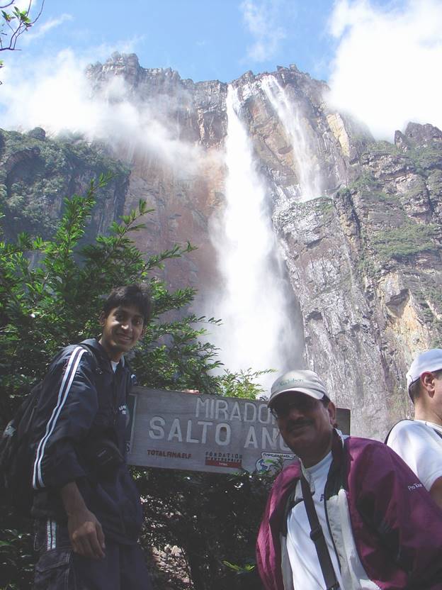 A group of men standing in front of a waterfall  Description automatically generated