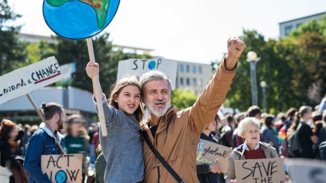 A person and a child holding signs  Description automatically generated