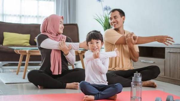 A group of people sitting on the floor with their hands on their head  Description automatically generated