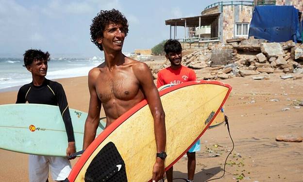 Attiq Ur Rehman, 21, walks with his teammates along the beach as they prepare to surf at Turtle Beach in Karachi, Pakistan, September 4, 2024. REUTERS/Insiya Syed