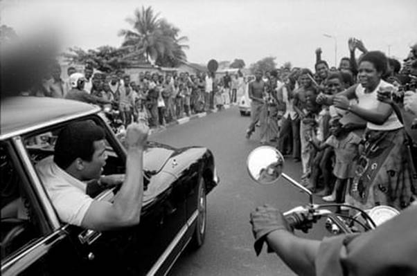 Muhammad Ali is cheered by a crowd as he drives in downtown Kinshasa for a sightseeing trip ahead of his fight against George Foreman.