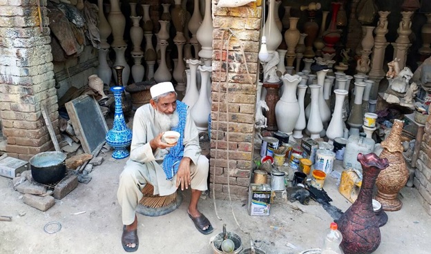 A person sitting in front of many vases  AI-generated content may be incorrect.