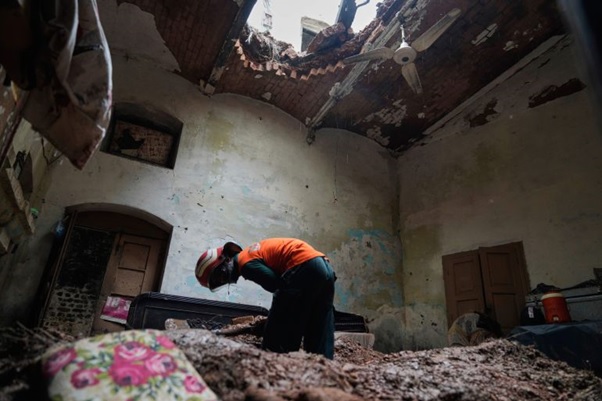 A rescue worker removes debris from a house that collapsed after heavy rain in Lahore, Pakistan, Thursday, July 10, 2025. (AP Photo/K.M. Chaudary)