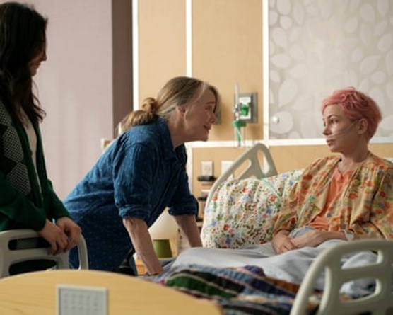 Movie still of a hospital room, with one woman in bed and two beside her