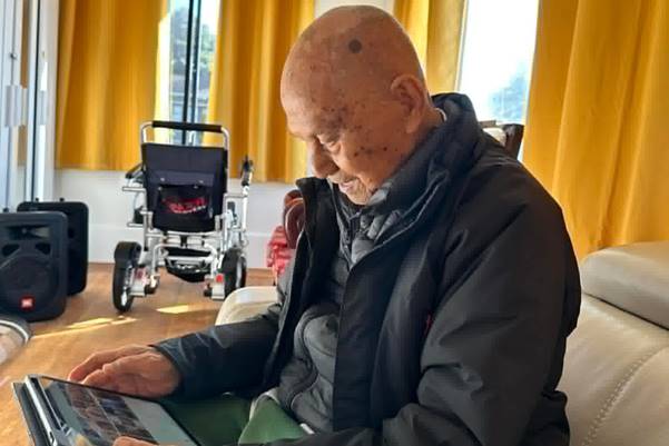 A person sitting in a chair looking at a computer  AI-generated content may be incorrect.