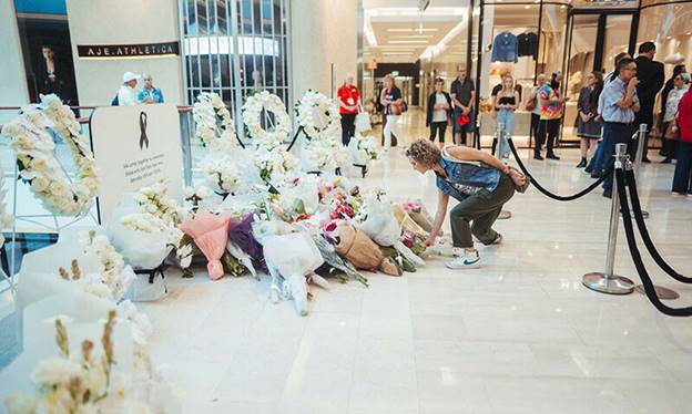 A woman places flowers at a memorial setup inside of the Westfield shopping centre in Bondi Junction in Sydney on April 18. — AFP