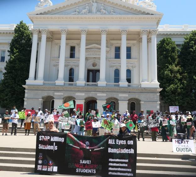 A group of people protesting in front of a white building  Description automatically generated