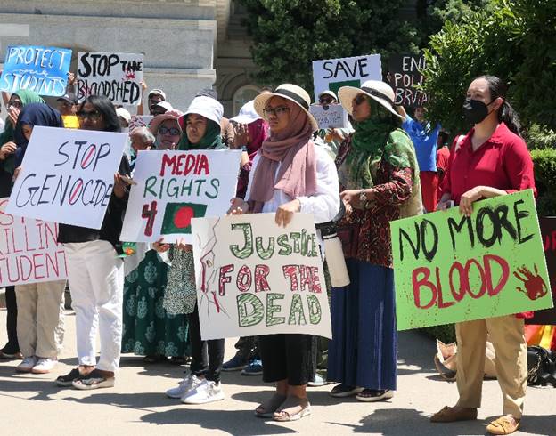 A group of people holding signs  Description automatically generated