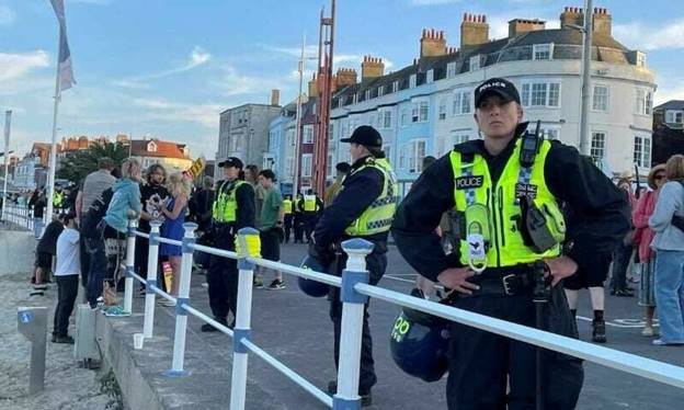 Police wearing riot protection equipment patrol the seafront esplanade following an anti-immigration protest in Weymouth, Britain, August 4. — Reuters