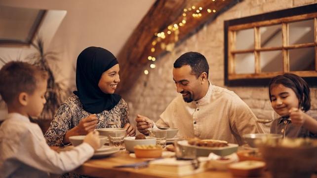 A group of people eating at a table  Description automatically generated