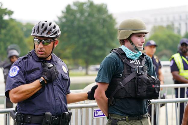 A police officer and a person in helmets  Description automatically generated with medium confidence