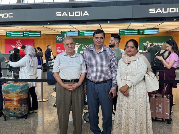 A group of people standing in an airport  Description automatically generated