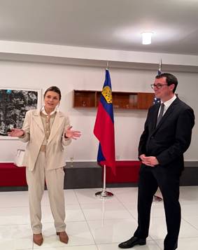 A person and person standing in a room with flags  AI-generated content may be incorrect.